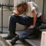 a man sitting on a step with his head in his hands