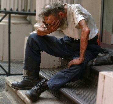 a man sitting on a step with his head in his hands